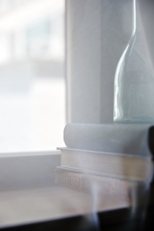 Books and glass bottles at the window.の写真素材
