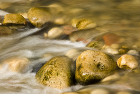 water flowing around colorful rocks in a river bed