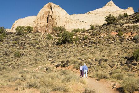 Visitors hike along the trail to Hickman Bridge in Capital Reef National Park in southern Utah.  Capital Dome formation in the background.の写真素材