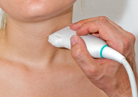 Young patient undergoing ultrasound of thyroid gland in hospital room