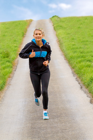 Girl jogging on a way in natureの写真素材