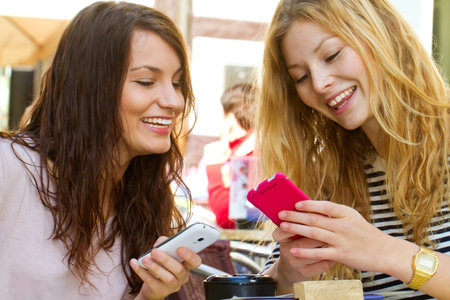 Girls with smartphones in a cafe