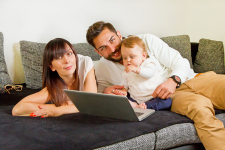 Family on a couch with laptopの写真素材