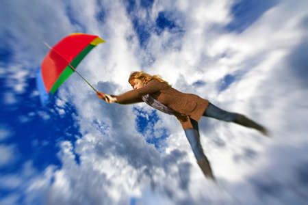 Woman flying with umbreallaの写真素材