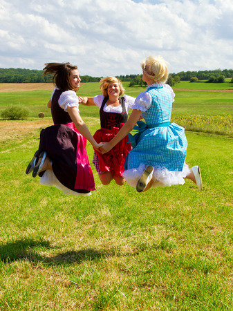 Girls in colorful dirndls having funの写真素材