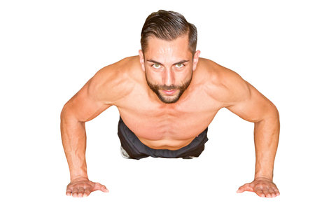 Athletic man making push ups - isolated on white background