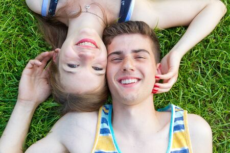 Young, happy couple lying on a meadowの写真素材