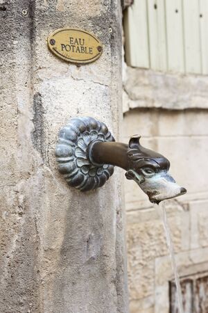 Bronze metal spout in an antique public fountain in Gigondas, vaucluse, France. Bronze metal spout in an antique public fountain in Gigondas, vaucluse, France.