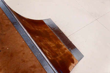 Detail of a wooden and metal quarter pipe ramp with rail in a skate park. Copy-space for placing...