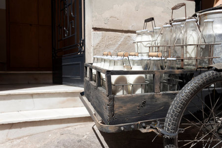 Bottles and aluminum cans of milk for delivery in vintage rusty milkman bicycle.
