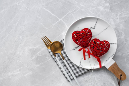 Banner. table setting. A fashionable marble plate with a napkin, fork and red hearts on a gray background. Valentine's Day holiday concept for cafes and restaurants. A copy of theの写真素材