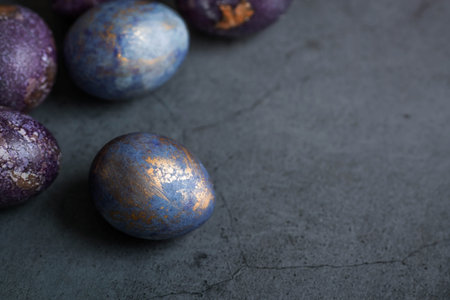 Easter card with a copy of the place for the text. Purple, blue and golden eggs on a dark...
