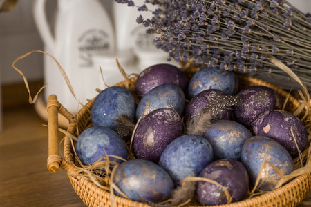 Easter card with a copy of the place for the text. Purple, blue and golden eggs in a basket on a...