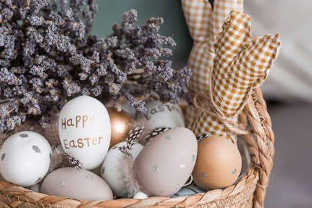 beautiful postcard. A wicker basket with Easter eggs, lavender and rabbits in close-up. provence. The concept of the bright Easter holiday 2022.の写真素材