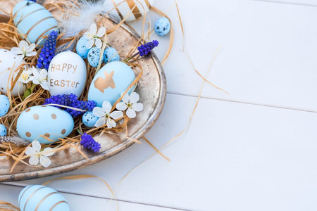 Banner. Easter card of 2022. Festive white and blue cherry blossoms on an iron tray on a white...