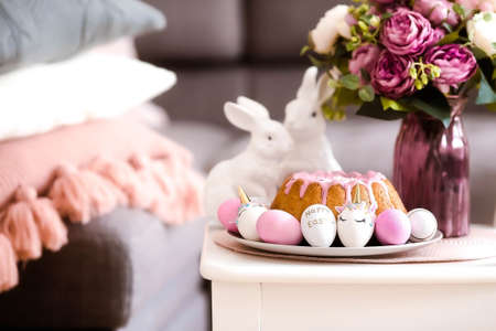Banner. minimal concept. Easter cake, rabbits and eggs in the form of a unicorn and with a gold pattern on a white table. Copy space for text.の写真素材