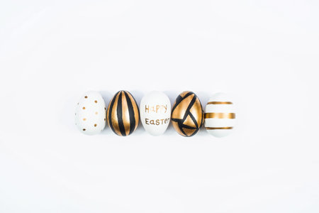 Golden, black, white Easter eggs on a white background. geometry. minimal concept. top view. A card...