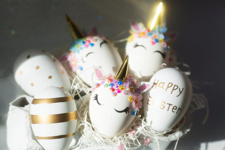 Banner. Easter eggs in the form of a unicorn, and with a gold pattern on a white background. flat...