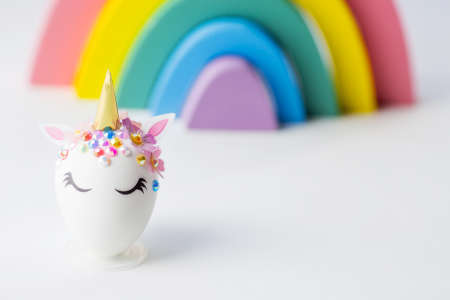 Minimal easter concept. Easter eggs in the shape of a unicorn on a rainbow background. flat lay. Copy space for text. The portfolio has more Easter pictures.の写真素材