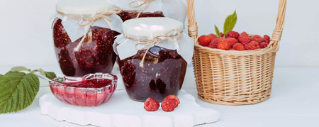 Homemade healthy jam with raspberries on a white wooden table. Treatment of colds. conservation and...