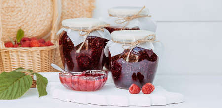 Homemade healthy jam with raspberries on a white wooden table. Treatment of colds. conservation and summer harvesting.の写真素材