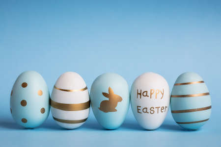 Easter painted eggs isolated on trendy blue background. The minimum concept. Card with copy space for text.の写真素材