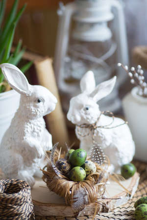 Painted quail eggs and beautiful white rabbits. Easter card. The concept of a bright happy Easter 2022.の写真素材