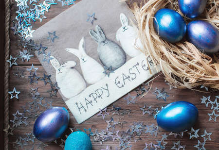 Blue Easter eggs in nest on wooden background. Minimal easter concept. Easter card with copy space for text.の写真素材