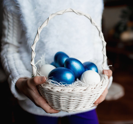 Easter eggs in a basket in the hands of a woman.の写真素材