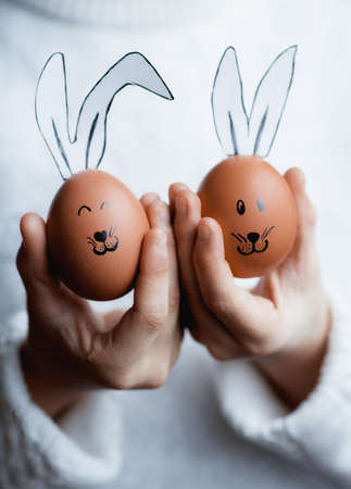 Easter eggs in the form of a rabbit in the hands of the girl. The concept of a happy bright Easter.の写真素材