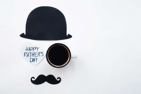 Holiday concept Father's Day. Flatlay Hat, bow tie, red heart and funny black mustache on a white background. Copy space for text.の写真素材