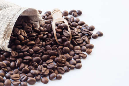 The menu of cafes and restaurants. Coffee beans and wooden spoon close-up. Copy space for text. The concept of hot drinks.の写真素材