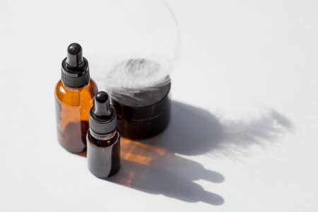 Layout of the beauty salon branding. Glass dropper bottle and pen on a sunny day on a white background. Natural organic eco-cosmetics.の写真素材