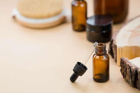 aromatherapy. On a wooden stand was a glass bottle with a pipette for oil, and a massage brush. Natural organic eco-cosmetics. Layout of the beauty salon branding.の写真素材