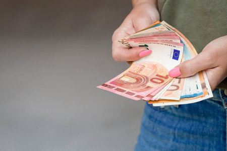 Women's hands close-up. A woman holds Euro banknotes in her hands and counts them. The concept of...