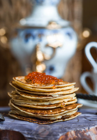 Delicious pancakes with red caviar. Russian and Ukrainian cuisine. The concept of the Maslenitsa...