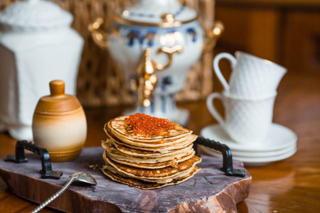 Delicious pancakes with red caviar. Russian and Ukrainian cuisine. The concept of the Maslenitsa...