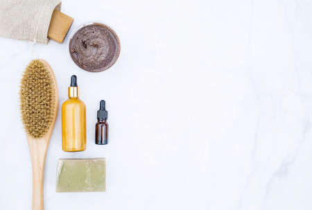 Cosmetology, peeling, spa cosmetic products, beauty concept.Natural ingredients for home skin care.Organic wooden brush for dry anti-cellulite massage, bottle with dispenser on white background.の写真素材