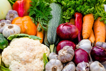 A wicker basket full of fresh raw vegetables. Basket of vegetables (cauliflower, carrots, cucumbers,...