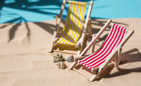 A toy beach chaise longue, seashells, a starfish on white sand with shadows. Sunlight. The concept of the sea, a beach holiday and a resort. summer minimalism.の写真素材