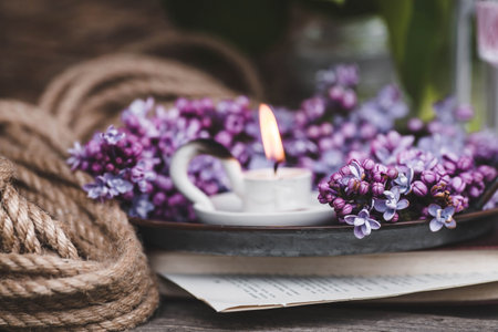 Still life with lilac flowers, cup of coffee and book on wooden backgroundの写真素材