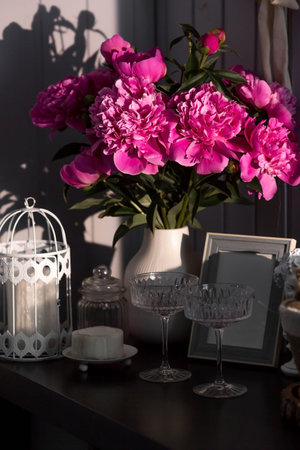 A beautiful pink bouquet of peonies in the sunlight on a black table. The interior of a country house in the style of Provence. The concept of home comfort and decor in the house.の写真素材