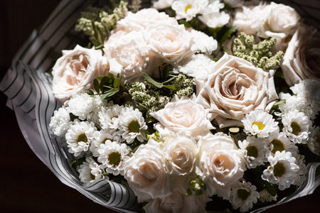 Bouquet of white roses and chamomile in a basketの写真素材
