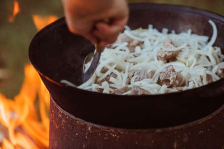 Recipe for traditional oriental pilaf in a cauldron in nature. Cooking. recipes. Step by step photo instructions for cooking pilaf.の写真素材