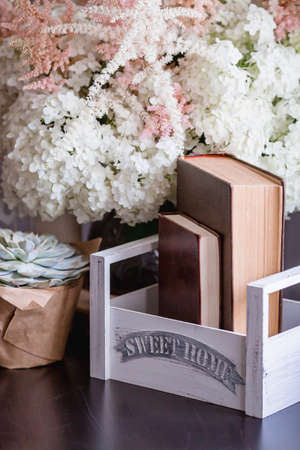Details of a still life in the home interior of the living room. Books, a vase with hydrangea and astilba flowers, succulent. Read and relax. Cozy home concept.の写真素材
