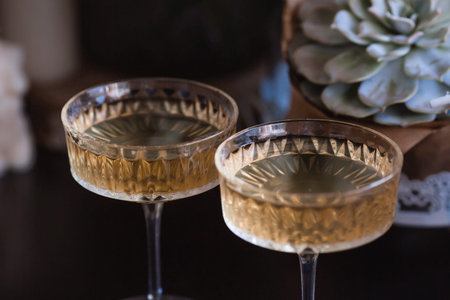 A bouquet of white hydrangeas and pink astilba, succulent, candles and a fashionable glass for dessert and champagne with wine inside. Cozy interior. The concept of a party, weddingの写真素材