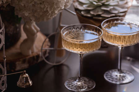 A bouquet of white hydrangeas and pink astilba, succulent, candles and a fashionable glass for dessert and champagne with wine inside. Cozy interior. The concept of a party, weddingの写真素材