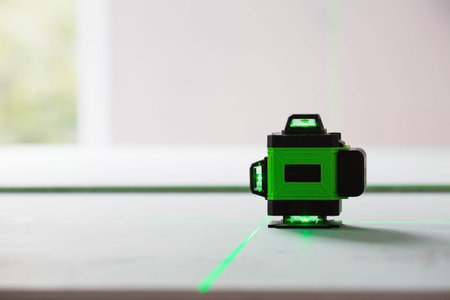 Construction and finishing works indoors. Laser construction level with green beams on the wall....