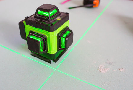 Construction and finishing works indoors. Laser construction level with green beams on the wall. Apartment renovation and construction work.の写真素材