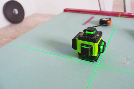 Construction and finishing works indoors. Laser construction level with green beams on the wall....
